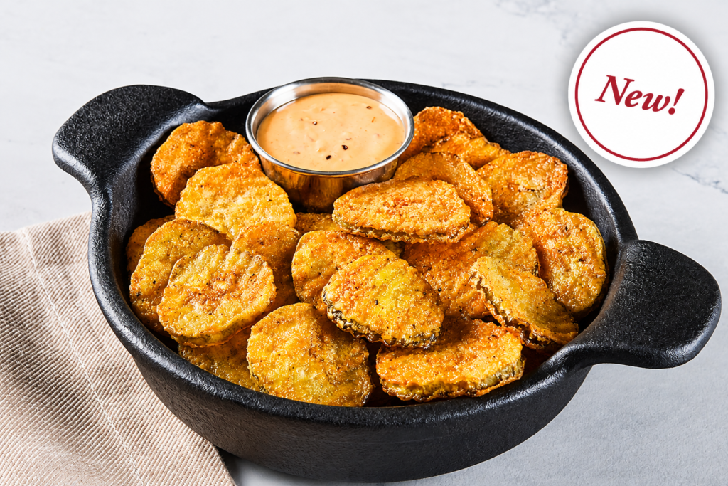 Shareables & Sides, Crispy fried pickle chips served hot in a skillet with creamy dipping sauce for a crunchy shareable appetizer.